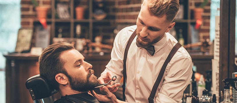 Man receiving beard trim in barber shop