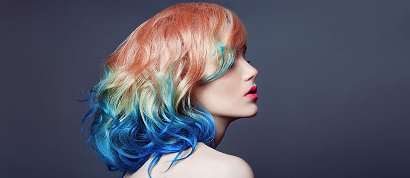 Side profile of a woman with brightly colored hair.