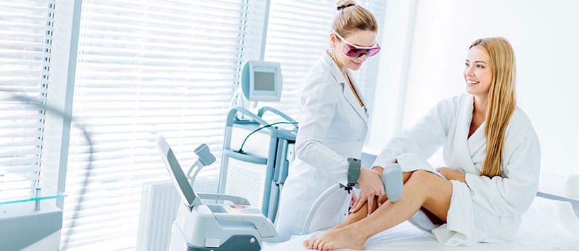 Woman receiving electrolysis treatment on her legs.