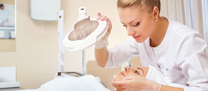 Esthetician examining a woman's skin.