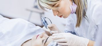 Permanent makeup treatment being done to a woman's eyebrows.