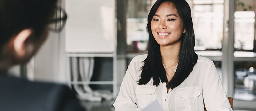 Woman smiling during a meeting in an office.