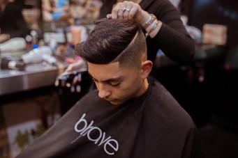 Man receiving barbering services