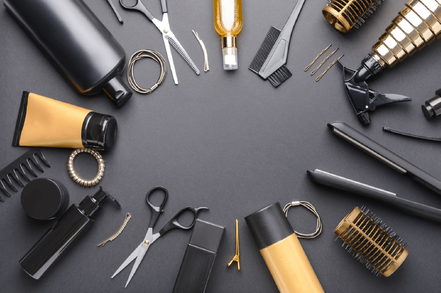 Barbering tools laid out on a black surface.